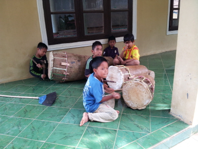 크기변환_야자수 나무에 홈을 파내고 거칠게 다듬어진 염소 가죽을 씌워 만든 북을 두들기는 산마을 아이들.jpg